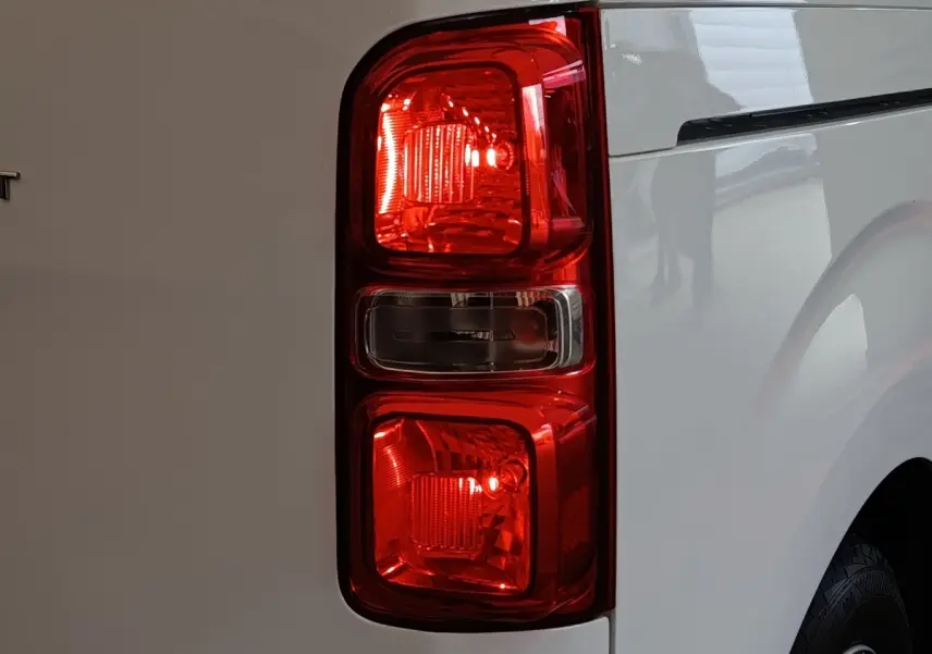 Gros plan sur le feu arrière droit rouge du Peugeot Expert Fourgon blanc, vue latérale arrière.