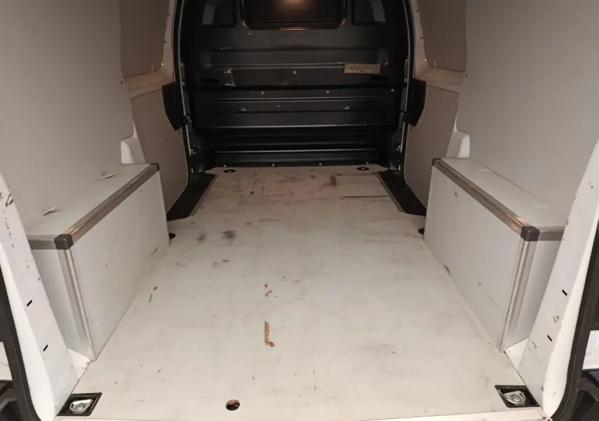Vue intérieure arrière du fourgon blanc Peugeot Expert avec espace de chargement vide et cloison pleine noire.