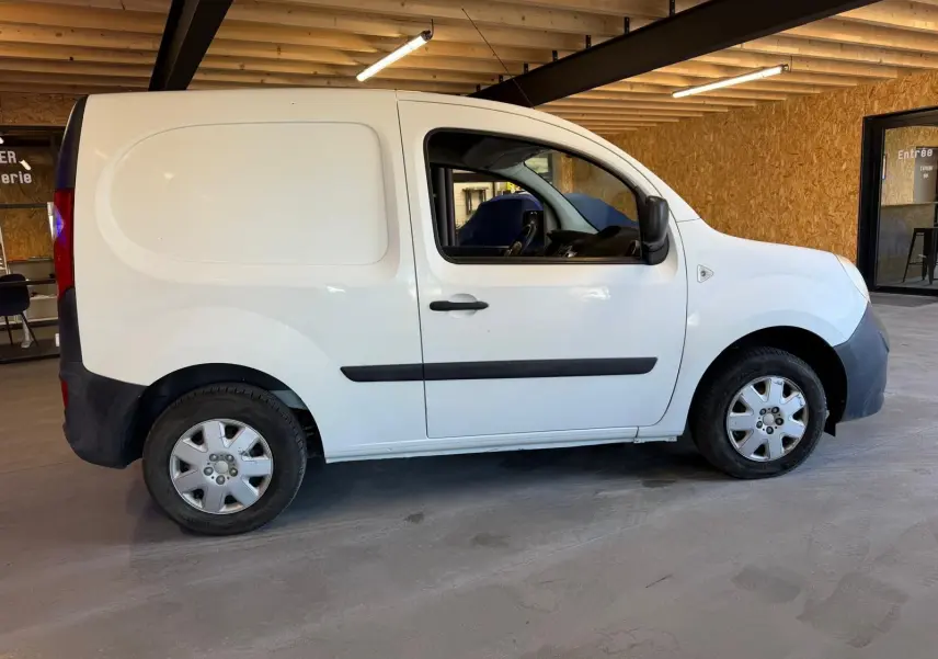 Profil côté gauche d’un Renault Kangoo blanc 2011, version utilitaire compacte avec portes pleines et jantes acier.