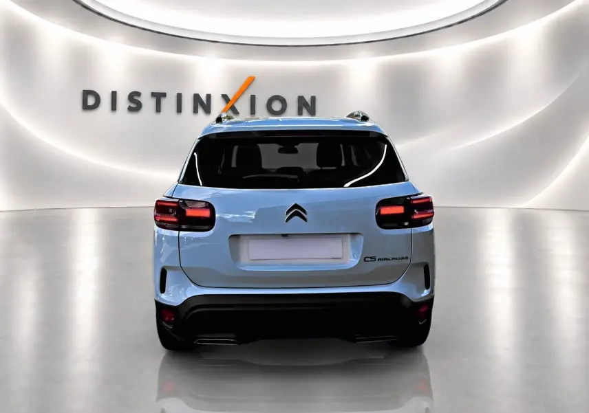 Vue arrière d'un Citroën C5 Aircross blanc 2025 dans un showroom lumineux avec logo Distinxion en arrière-plan.