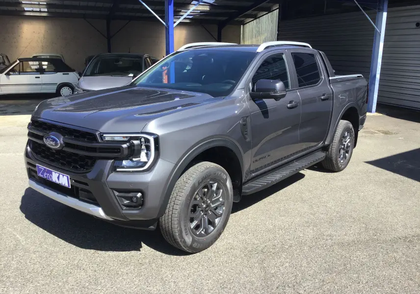 Ford Ranger Double Cabine gris carbone vu en 3/4 avant droit, avec marchepied et jantes alliage visibles.