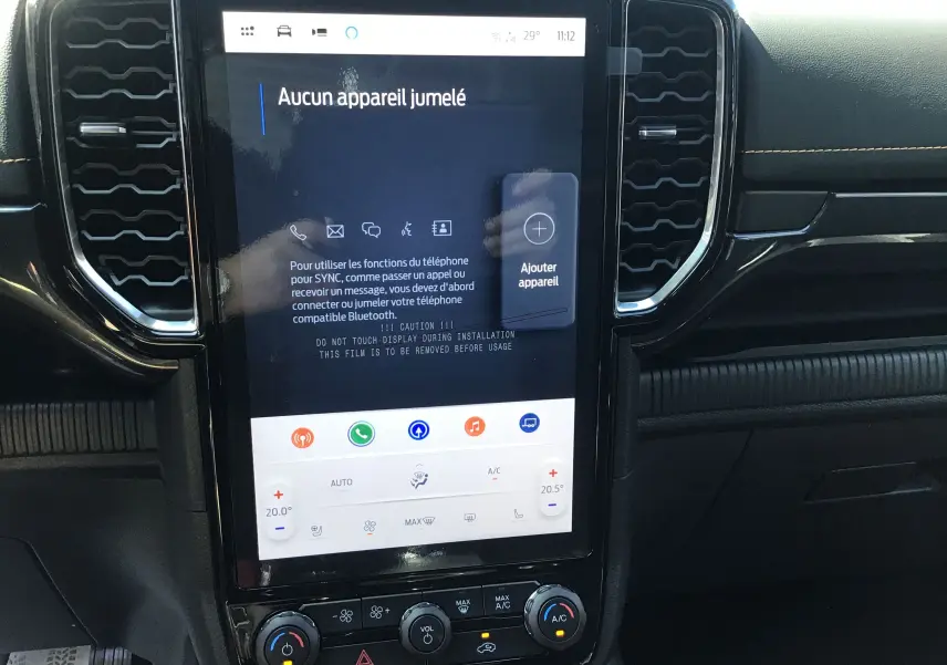 Écran tactile central du Ford Ranger Wildtrak avec interface SYNC 4 et commandes climatisation visibles sur tableau de bord noir.