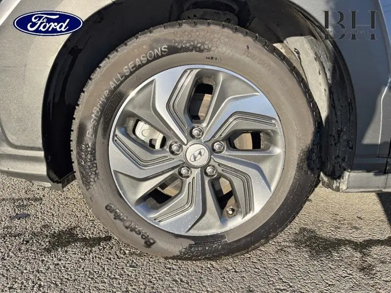 Gros plan sur la roue avant droite d’un Hyundai Kona 2022 Dark Knight Métal avec jante alliage et logo Hyundai au centre.