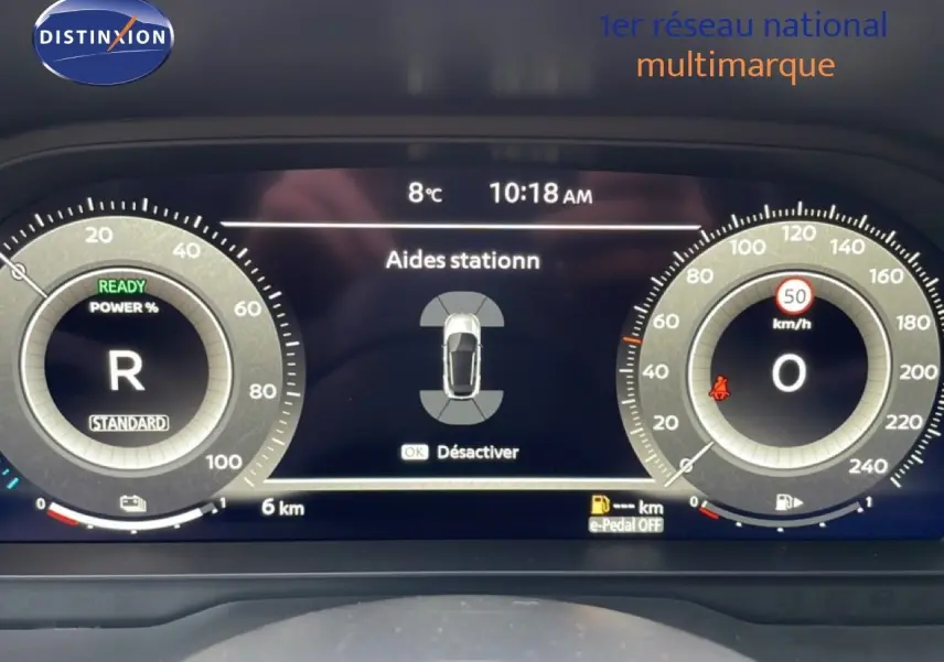 Tableau de bord numérique du Nissan Qashqai noir perle, affichant les aides au stationnement et la vitesse à 0 km/h.