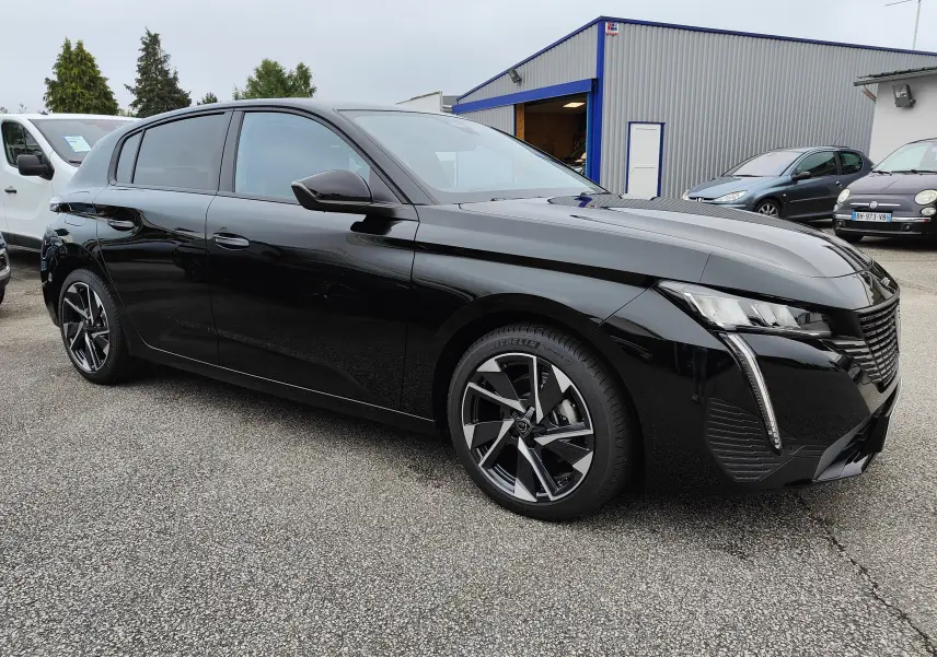 Peugeot 308 PureTech 130 Allure Pack noire vue en 3/4 avant droit, avec jantes bi-ton et phares LED distinctifs.