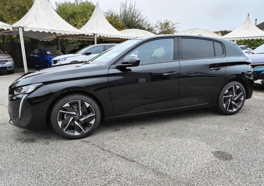 Peugeot 308 PureTech 130 Allure Pack noire vue de profil côté gauche, avec jantes alliage bi-ton et vitres teintées.