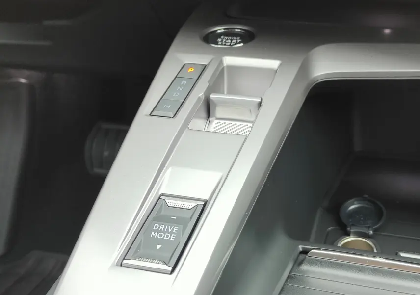 Gros plan sur la console centrale argentée de la Peugeot 308 PureTech 130 Allure Pack 2023, avec sélecteur modes de conduite.