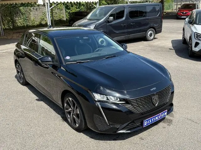 Peugeot 308 PureTech 130 Allure Pack noire vue 3/4 avant, avec calandre distinctive et jantes alliage biton.