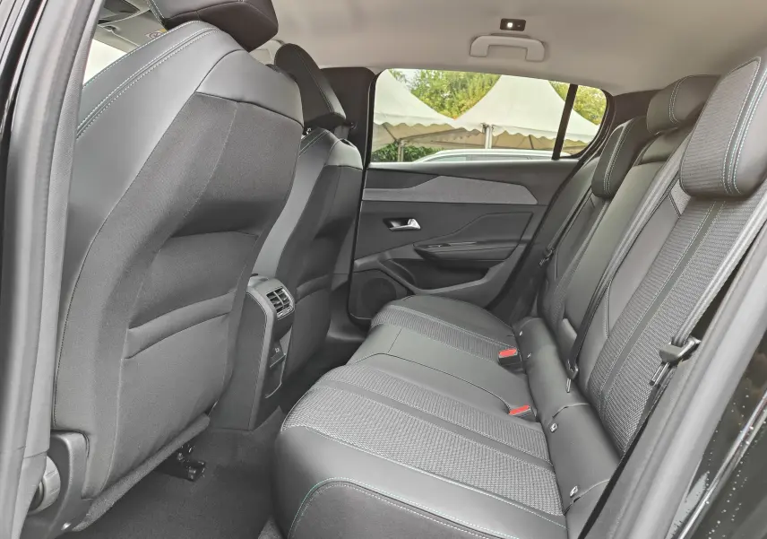 Vue latérale droite de l'intérieur arrière noir de la Peugeot 308 PureTech 130 Allure Pack avec sièges en tissu et cuir.