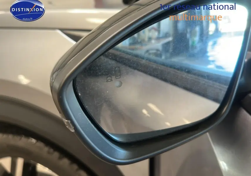 Rétroviseur extérieur côté gauche de la Peugeot 2008 gris artense, avec indicateur d'angle mort intégré.