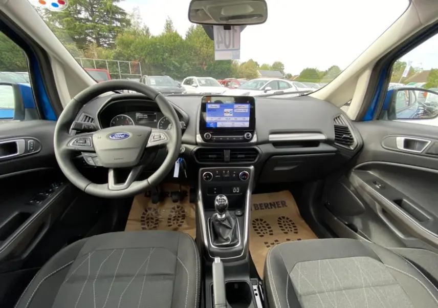 Vue intérieure avant du Ford EcoSport bleu Island 2022, montrant le volant, la boîte manuelle et l’écran tactile central.