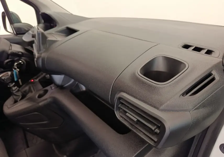 Vue intérieure côté passager du tableau de bord noir du Peugeot Partner 2022 avec porte-gobelet intégré.