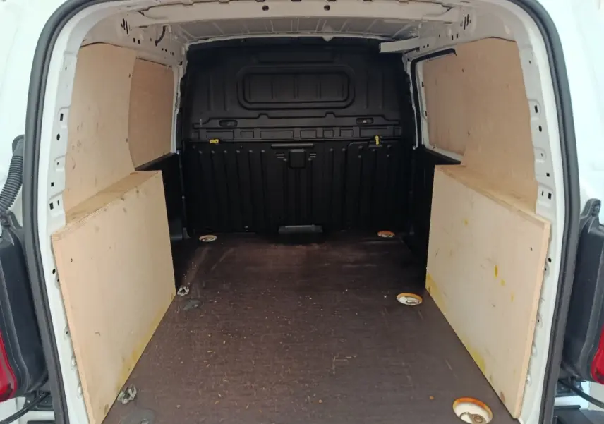 Vue intérieure arrière du coffre blanc du Peugeot Partner 2022 avec cloison pleine et plancher protégé en bois.