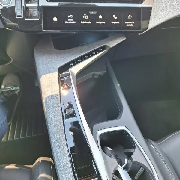 Vue intérieure du Peugeot 3008 Hybrid 136 e-DCS6 Allure 2025, console centrale avec écran tactile et finition tissu gris.