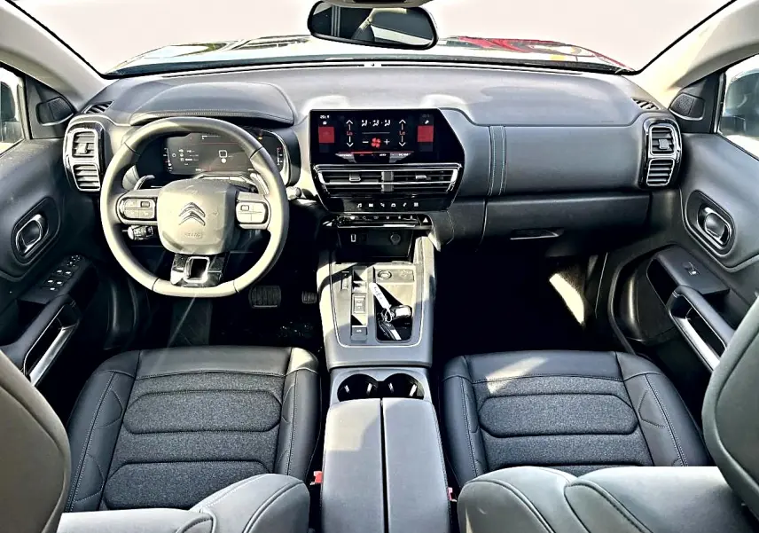 Vue intérieure avant du Citroën C5 Aircross 2025 noir, avec tableau de bord moderne et volant multifonction cuir.
