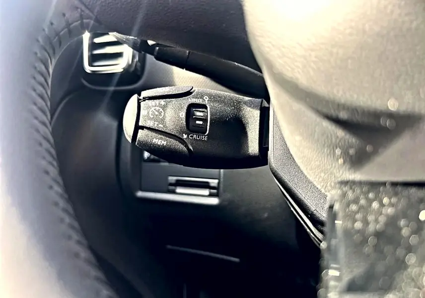 Gros plan sur la commande de régulateur de vitesse noire, côté gauche du volant cuir noir d'un Citroën C5 Aircross 2025.