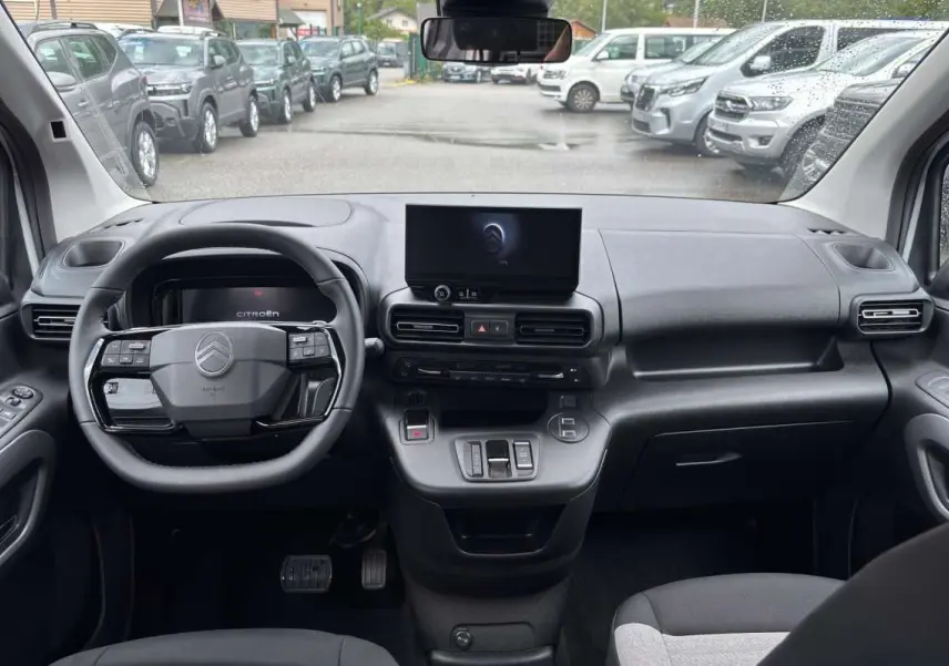 Vue intérieure avant du Citroën Berlingo Kaolin white 2026, tableau de bord moderne avec écran central et volant multifonctions.