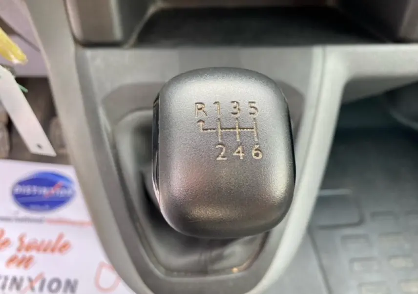 Gros plan sur le levier de vitesses manuel noir du Citroën Jumpy blanc, montrant les six rapports et la marche arrière.