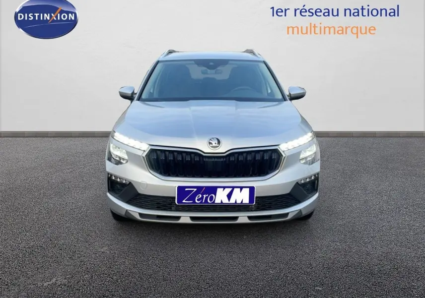 Vue frontale d'un Skoda Kamiq gris argent métal 2025 avec calandre noire et feux LED allumés.