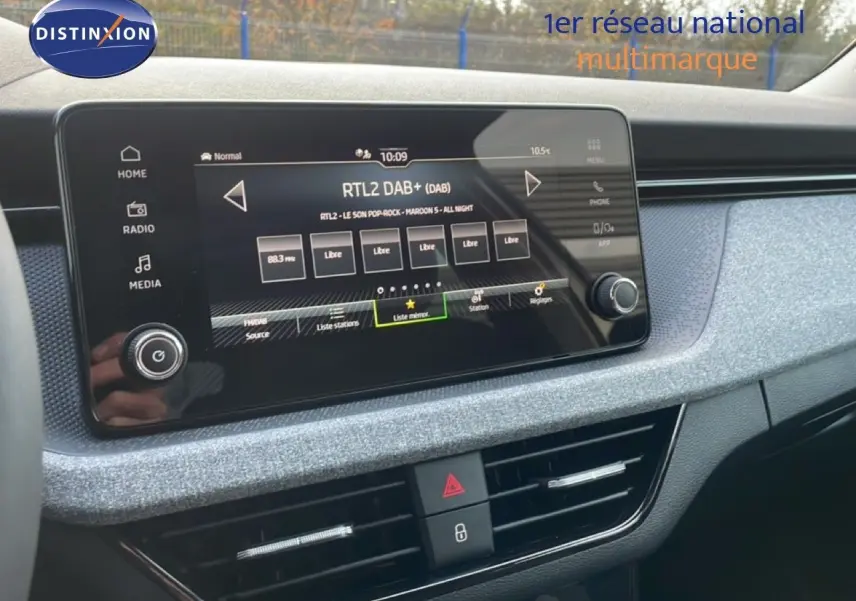 Écran tactile central du tableau de bord gris argent d'une Skoda Kamiq 2025, avec interface radio numérique visible.