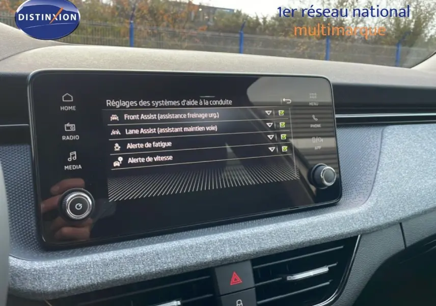 Écran central du tableau de bord du Skoda Kamiq gris argent 2025 affichant les aides à la conduite activées.