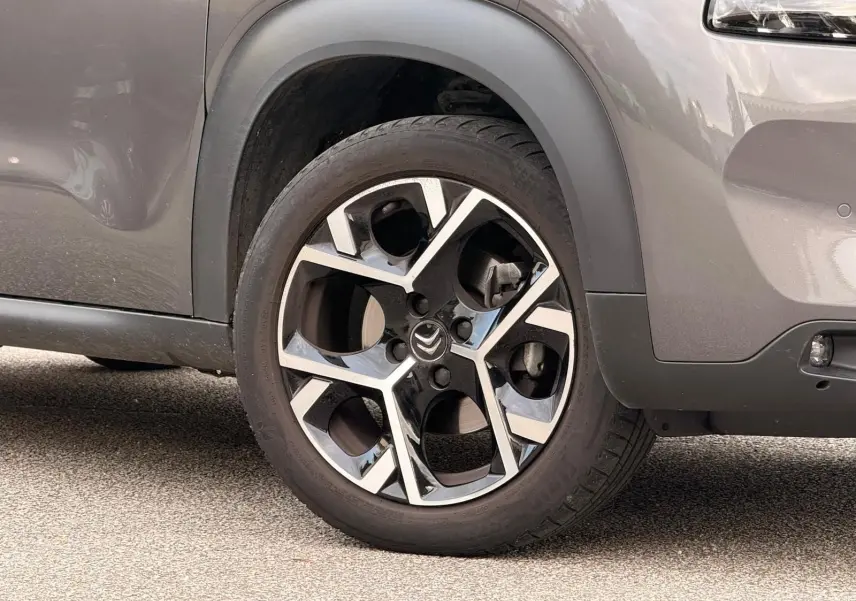 Gros plan sur la roue avant droite du Citroën C3 Aircross gris platinium, mettant en valeur la jante alliage au design moderne.
