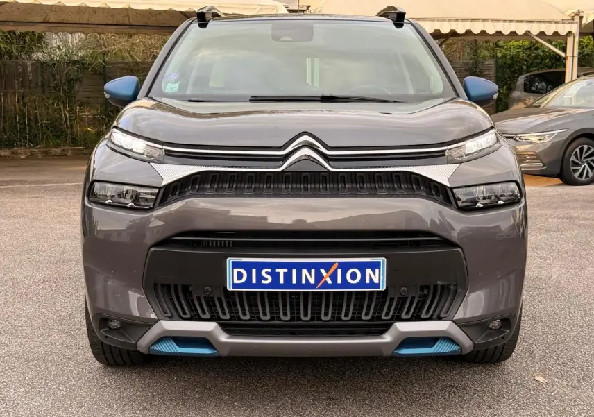 Vue frontale d'un Citroën C3 Aircross gris platinium 2022 avec calandre noire et détails bleus sur le pare-chocs.
