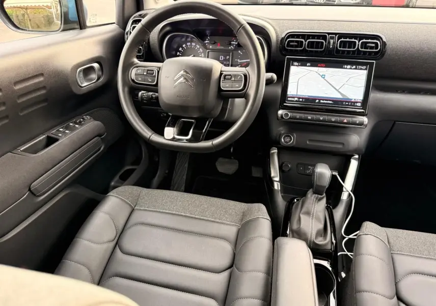 Vue intérieure avant de la Citroën C3 Aircross 2022, tableau de bord noir avec écran tactile et volant multifonction.