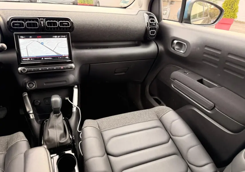 Vue intérieure côté passager du Citroën C3 Aircross 2022, montrant la console centrale avec écran tactile et sellerie grise.