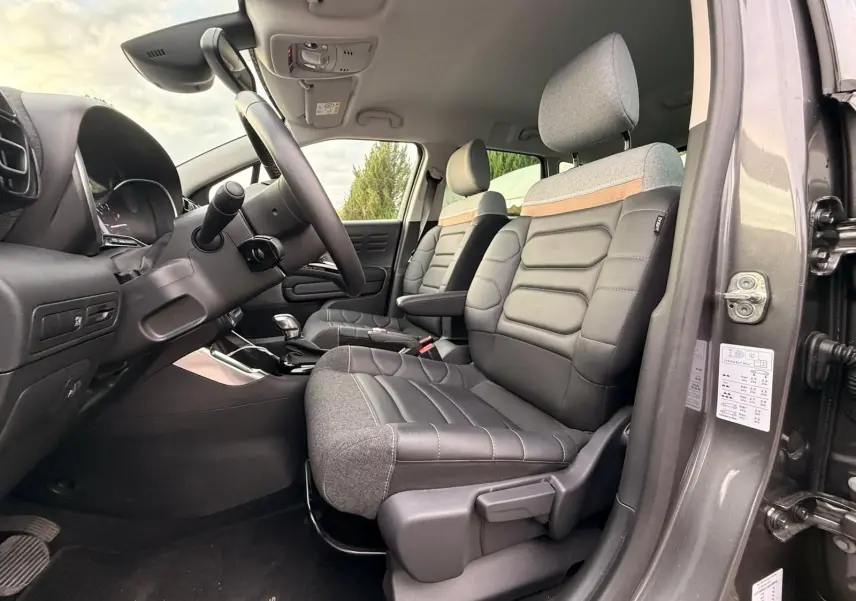 Vue intérieure côté conducteur du Citroën C3 Aircross gris platinium, mettant en valeur les sièges bi-matière et le tableau de bord.