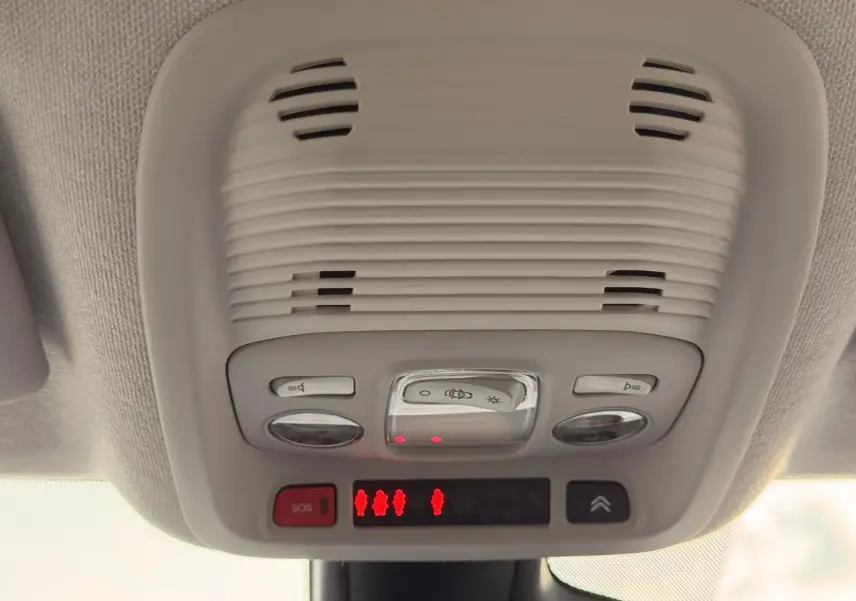 Vue en gros plan du plafonnier intérieur gris clair avec commandes d’éclairage et bouton SOS du Citroën C3 Aircross.