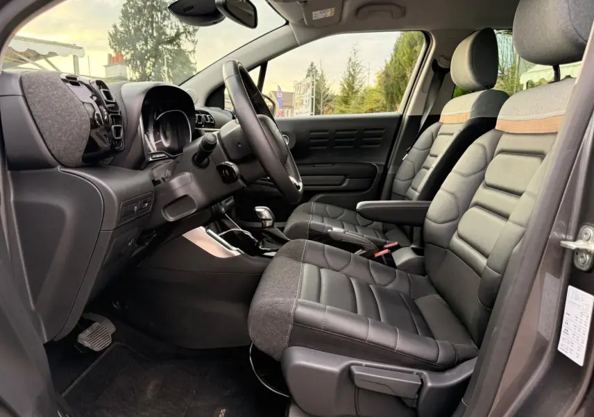 Intérieur avant droit du Citroën C3 Aircross gris platinium 2022, sièges bi-matière avec surpiqûres et tableau de bord moderne.