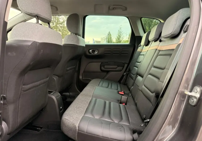 Vue intérieure côté droit des sièges arrière bi-matière gris clair et noir du Citroën C3 Aircross gris platinium 2022.