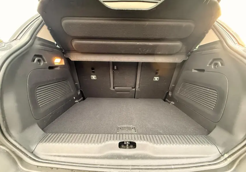 Coffre ouvert vu de l’arrière d’un Citroën C3 Aircross gris platinium, espace de chargement propre et spacieux.
