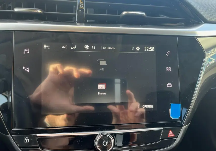 Écran tactile central de l’Opel Corsa 2022 affichant le menu photos, avec reflets et commandes tactiles visibles.