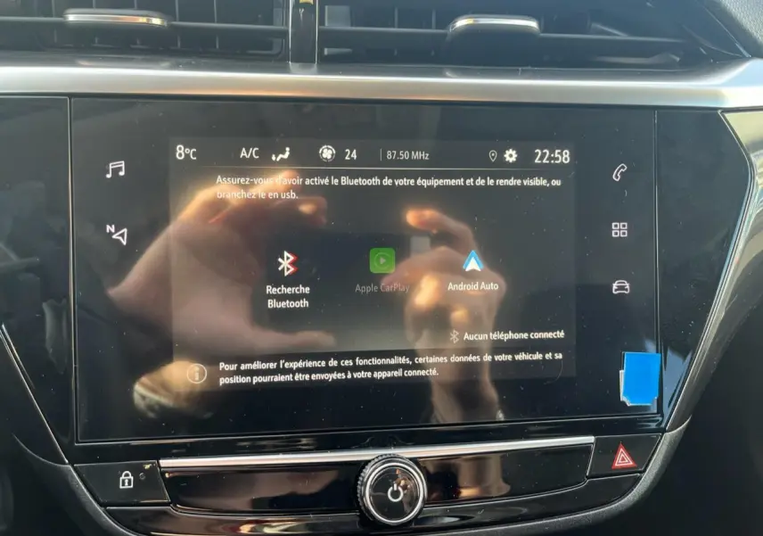 Écran tactile central de l’Opel Corsa 2022 affichant les options Apple CarPlay et Android Auto, avec reflets visibles.