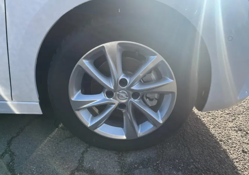 Gros plan sur la roue avant droite avec jante argentée de l'Opel Corsa blanche 2022, détails du pneu et jante visibles.