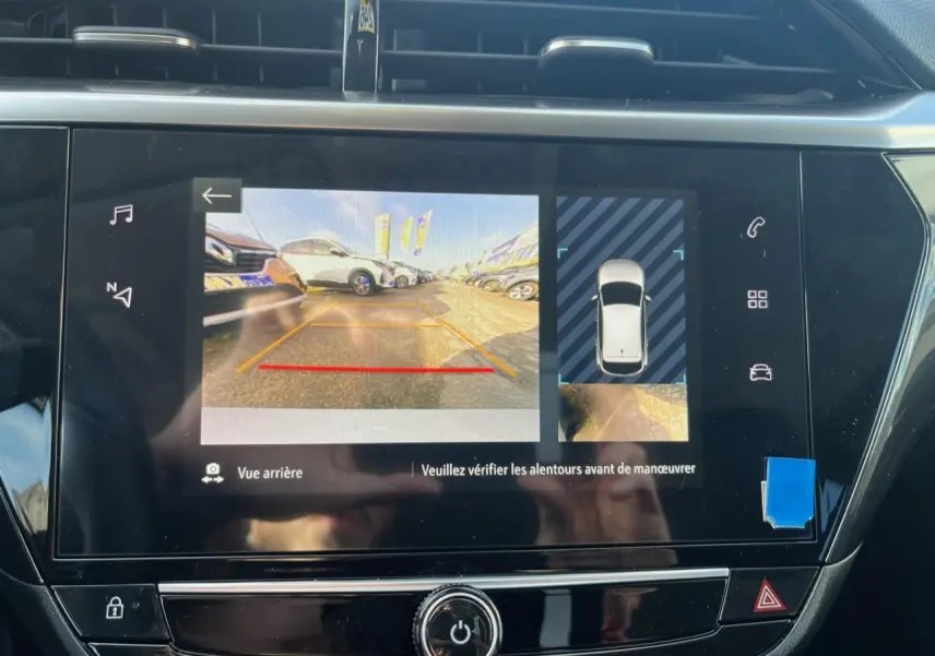 Écran digital de la caméra de recul affichant la vue arrière et la position du véhicule blanc Opel Corsa 2022.