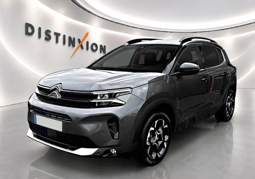 Citroën C5 Aircross gris platinium vue 3/4 avant droit, avec barres de toit et jantes alu distinctives.
