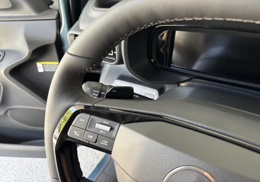 Gros plan sur le volant cuir multifonctions et le tableau de bord numérique du Citroën Berlingo Kiama blue 2026.