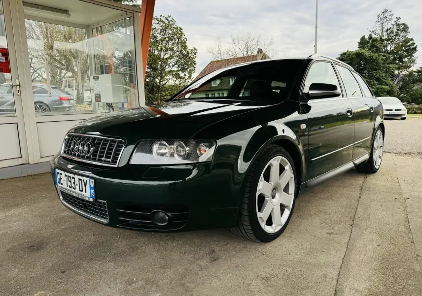 Audi S4 Avant vert foncé vue 3/4 avant droit, jantes alliage et calandre chromée sous un abri.