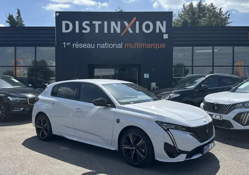 Peugeot 308 blanche vue de profil côté gauche, avec jantes alliage noires et calandre avant noire brillante.