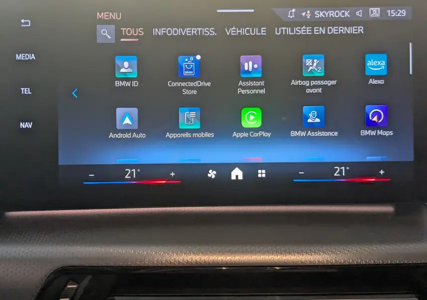 Écran tactile central du BMW X1 noir, affichant le menu principal avec options connectées et réglages climatisation.