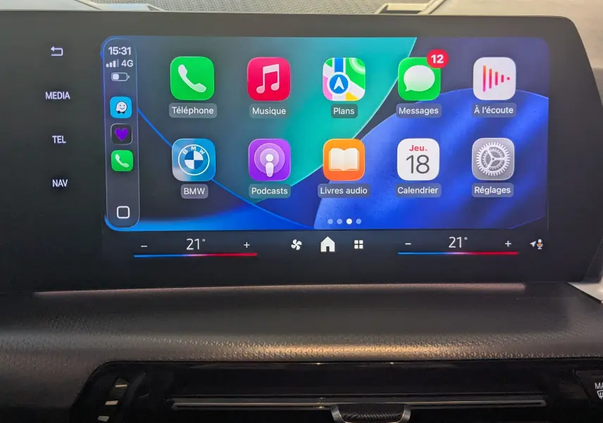 Écran tactile central du BMW X1 2025 affichant les applications de navigation, musique et téléphone, avec commande de climatisation.