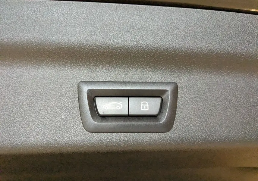 Gros plan sur les boutons d'ouverture et de verrouillage du coffre du BMW X1 noir, version M Sport 2025.