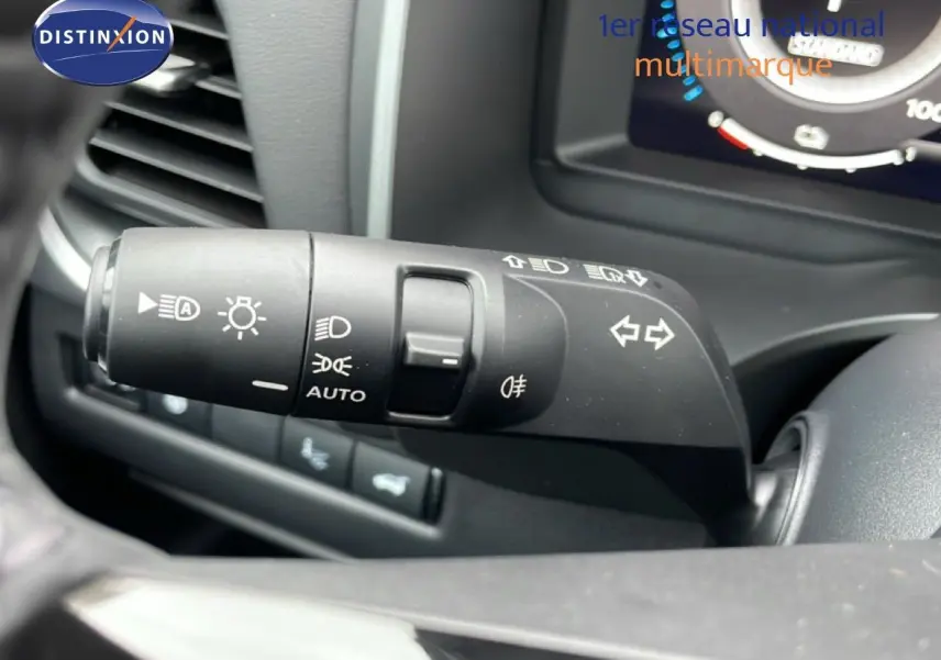 Gros plan sur la commande des feux et clignotants du Nissan Qashqai 2025, intérieur noir, détails des symboles lumineux.