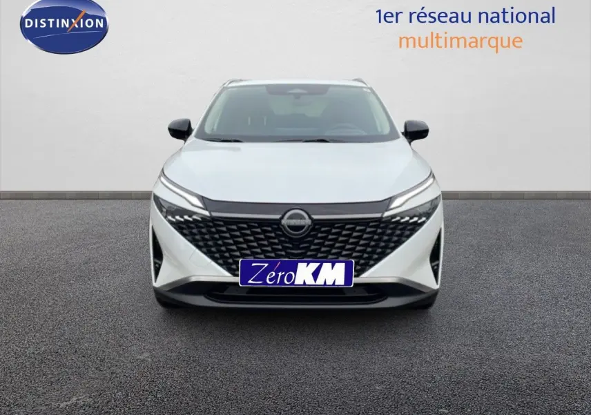 Vue frontale d'un Nissan Qashqai blanc nacré métal avec calandre noire texturée et phares LED fins.