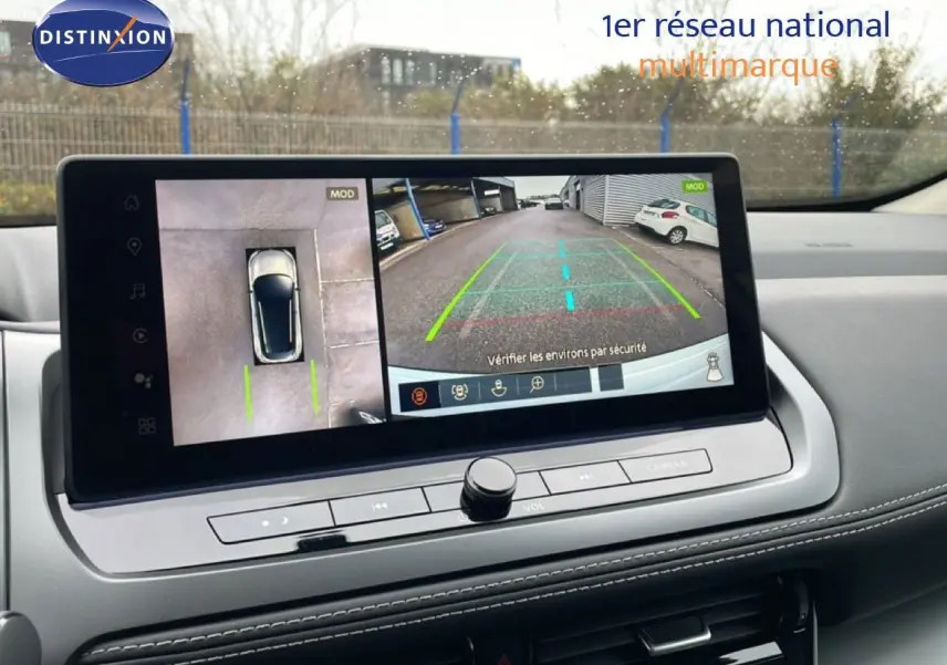 Vue intérieure sur l’écran central du Nissan Qashqai blanc nacré, affichant la caméra 360° et la vue arrière en stationnement.