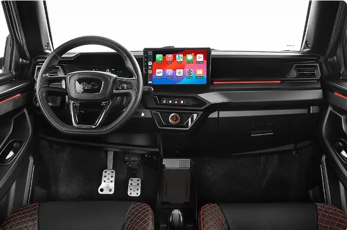 Vue frontale de l’habitacle noir et rouge du Ligier JS50 2026 avec écran tactile central et volant multifonctions.