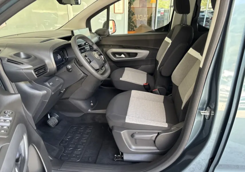 Vue intérieure côté conducteur du Citroën Berlingo Kiama blue 2026, sièges tissu bicolores et tableau de bord noir.